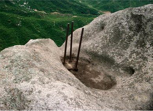 三根打在开城市天林山岩石上成三角形的铁桩